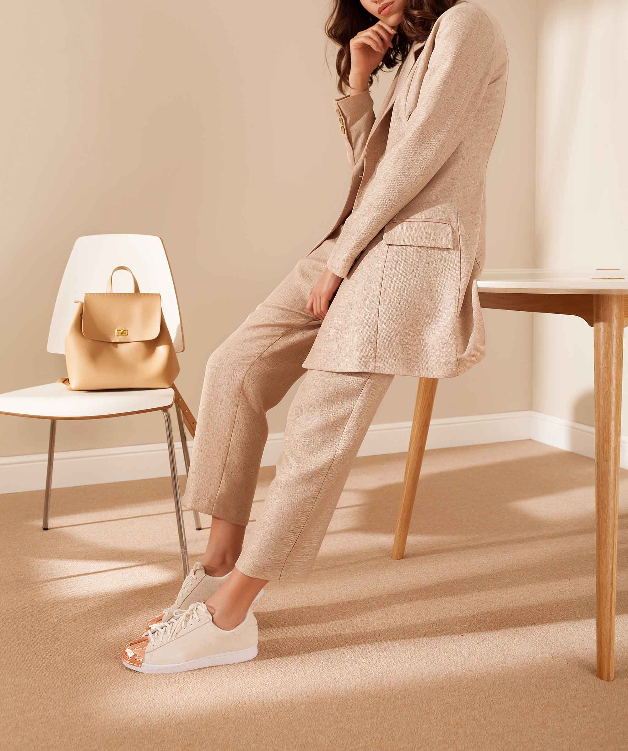 Professionally-dressed woman leaning against chair