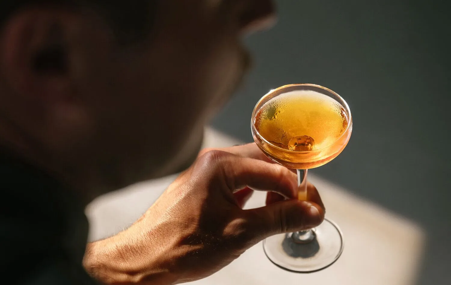 A silhouetted man enjoys a cocktail
